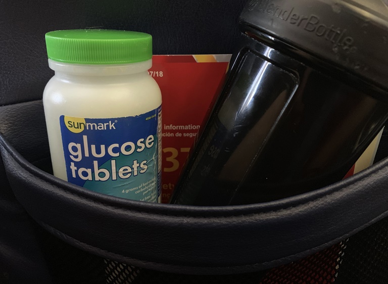 A bottle of glucose tablets, a plastic bottle and a small box of medication in a small bag
