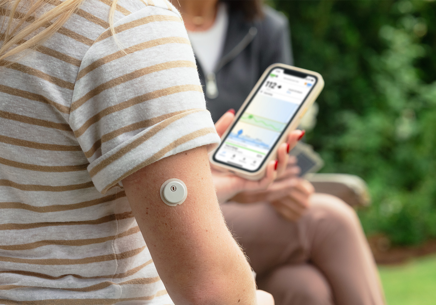 Pump User Looking at Mobile App while FreeStyle Libre 3 Plus Sensor is on their Arm