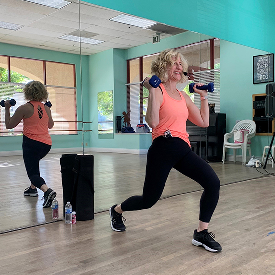A Jazzercise instructor, in a fitness studio, with the t:slim X2 insulin pump showing on her side.