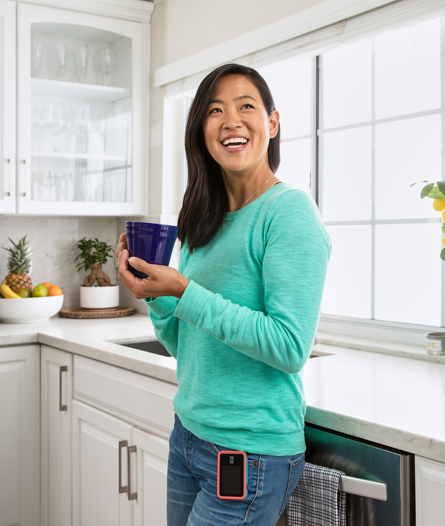 Tandem user with t:slim X2 pump drinking out of mug in kitchen